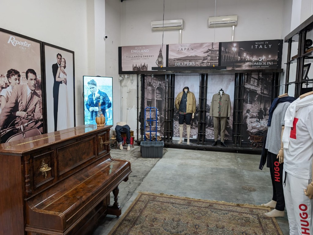 Joseph Uzumcu showroom interior with heritage tailoring displays and piano